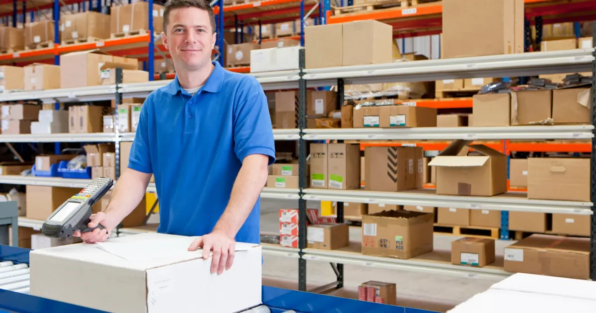 Verpacker scannt Pakete in einem modernen Logistiklager in Deutschland.