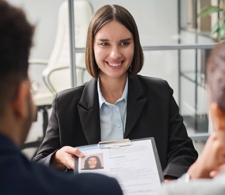 Recruiterin präsentiert Bewerbungsunterlagen im persönlichen Gespräch mit Kandidaten